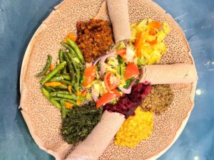 A plate with vegan injera and vegetarian specialties